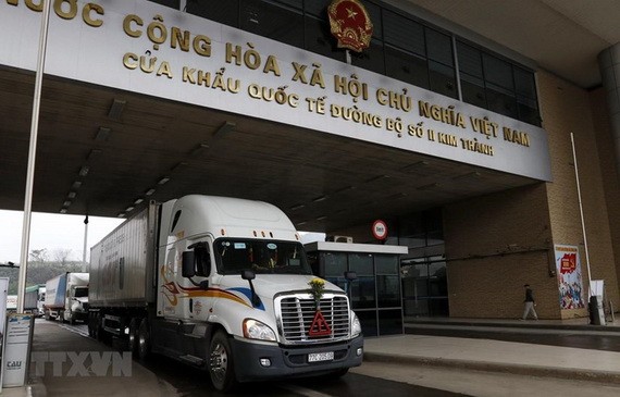 各輛農產品集裝箱車在金城2號口岸等待辦理出口中國的手續。