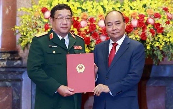 國家主席阮春福（右）向國防部副部長范懷南中將頒授晉升上將軍銜《決定》。（圖源：越通社）