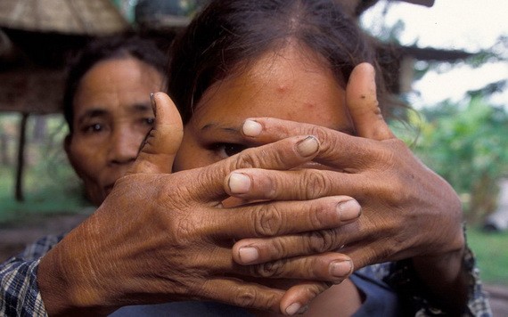 一位母親遮住了女兒的臉，以保護她的身份。女兒在 16 歲時被拐賣。（圖源：UNICEF）