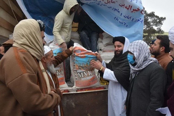 12月15日，阿富汗教師在馬扎里沙裡夫領取當地企業援助的人道主義物資。（圖：新華社）