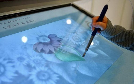 參觀展覽人士使用多媒體設備為水墨畫作填色。（圖：互聯網）