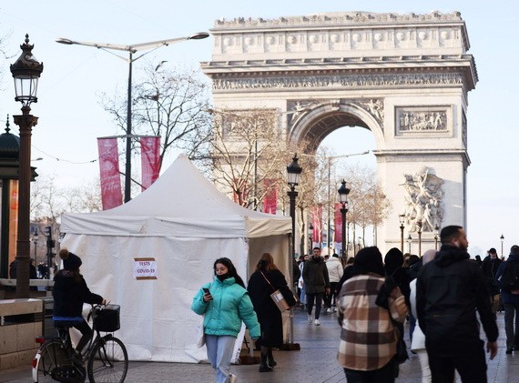 人們走過法國巴黎凱旋門附近的一處新冠病毒檢測點。（圖：新華社）