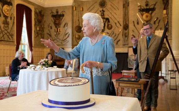 英國女王伊麗莎白二世5日在桑德令罕府切蛋糕。（圖：AFP）