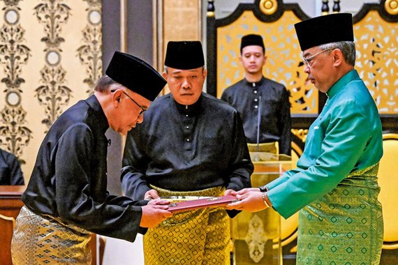 馬來西亞最高元首阿卜杜拉（右）24日任命安瓦爾（左）為總理。（圖：路透社）