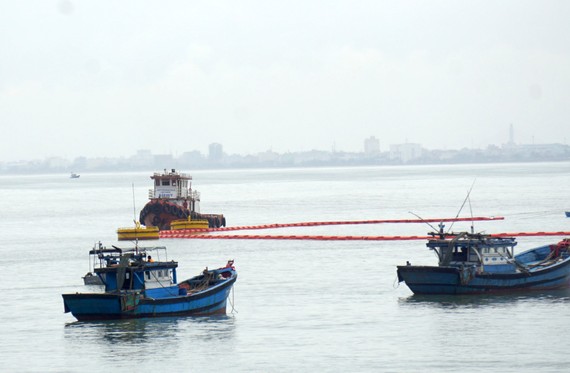 Các lực lượng cứu hộ cứu nạn triển khai các biện pháp chống tràn dầu trên biển sau khi va chạm giữa tàu chở dầu và cầu cảng tiếp dầu
