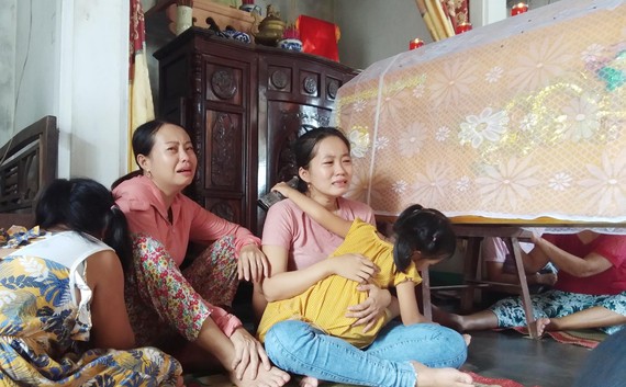 Chị Nguyễn Thị Ly và con gái ngồi thẩn thờ bên quan tài anh Khải