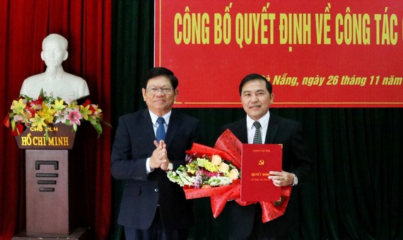 Ông Võ Công Trí, Phó Bí thư Thường trực Thành ủy Đà Nẵng trao quyết định và tặng hoa chúc mừng nhà báo Nguyễn Đức Nam