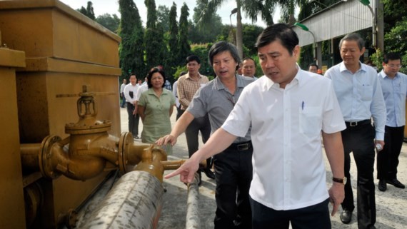 Chairman Nguyen Thanh Phong sees made in Vietnam gasification furnace, a technology that turns trash into a fuel, at Go Cat landfill site (Photo: SGGP)