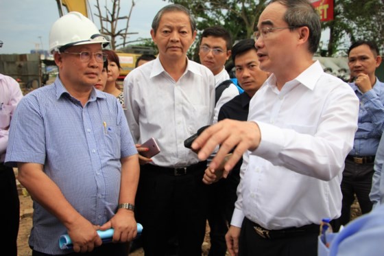 HCMC party chief Nguyen Thien Nhan and city People’s Committee deputy chairman Le Van Khoa survey the pump system installation area in Nguyen Huu Canh street on July 12 (Photo: SGGP)
