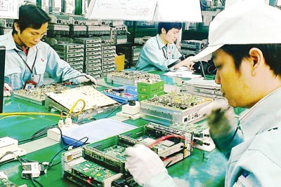 Workers making telecoms equipment at a plant of Viettel, a state-owned enterprise operated by the Ministry of Defense (Photo: SGGP)