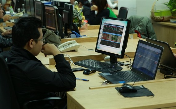 Investors watch market movements at the Military Bank Securities (MBS) trading floor. (Photo: VNS)