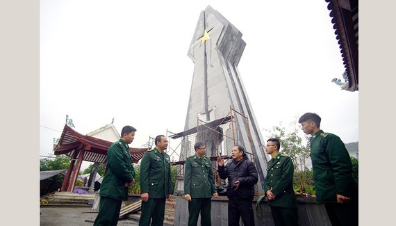 Mr. Hoang Nhu Ly (3rd, R) and soldiers at Po Hen Border Post talk together by Po Hen Monument (Photo: SGGP)