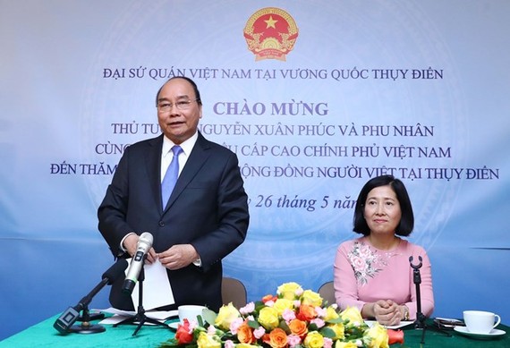 Prime Minister Nguyen Xuan Phuc (standing) speaks at the meeting with the Vietnamese Embassy staff and expatriates in Sweden. (Photo: VNA)