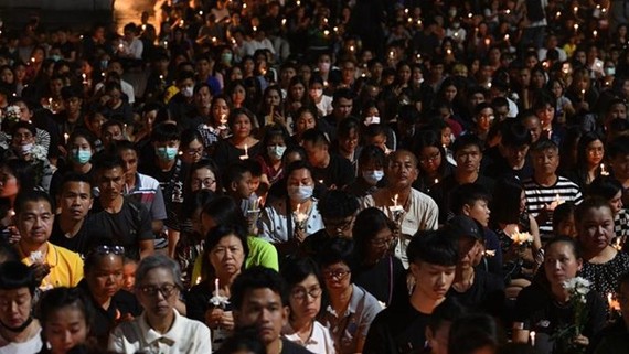 People take part in a candle-lit vigil for victims following the mass shooting in Nakhon Ratchasima (Source: AFP)
