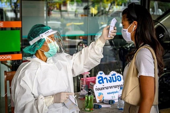 Temperature check for a person in Bangkok, Thailand (Photo: AFP/VNA)