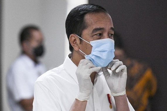 President Joko Widodo adjusts his face mask while visiting COVID-19 patients (Photo: AFP)