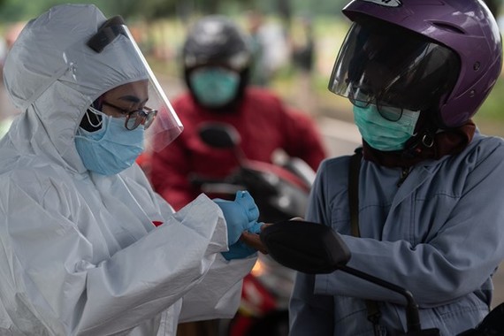 A health worker takes a motorcyclist's blood sample for COVID-19 testing in Tangerang city, Indonesia, on May 4 (Photo: AFP/VNA)