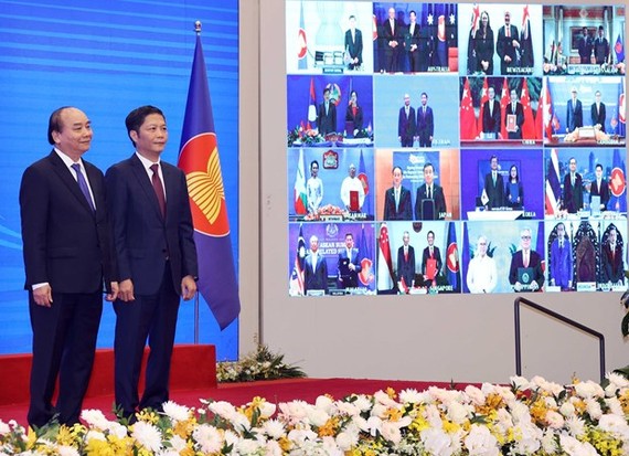 Vietnamese Prime Minister Nguyen Xuan Phuc (L) and Minister of Industry and Trade Tran Tuan Anh, together with leaders of other RCEP member countries, witness the pact signing via videoconference on November 15 (Photo: VNA)