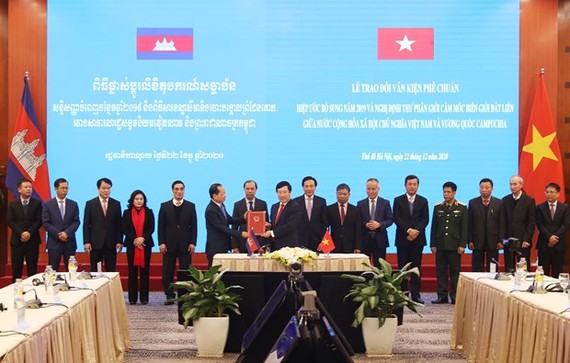 Deputy Prime Minister and Minister of Foreign Affairs Pham Binh Minh (front, right) hands over the ratification document to Cambodian Ambassador Chay Navuth in Hanoi on December 22 (Photo: VNA)