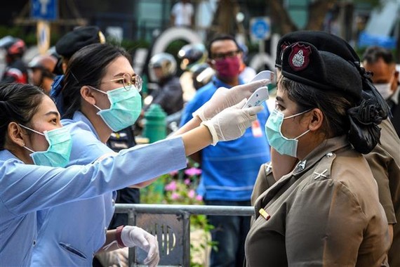 Medical workers check body temperature for police officers in Bangkok, Thailand (Photo: AFP/VNA)