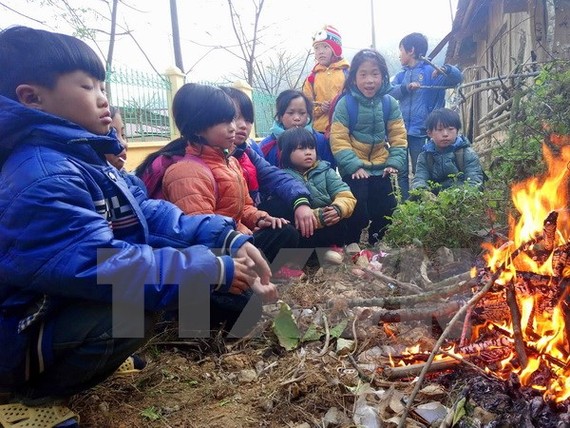Học sinh trường tiểu học Yên Lạc, huyện Nguyên Bình (Cao Bằng) co ro bên đống lửa. Ảnh: Quốc Đạt/TTXVN