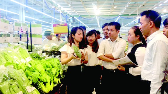 Nhân viên BigC tập huấn tại quầy mặt hàng rau ăn lá cho các hộ sản xuất huyện Nhà Bè.  Ảnh: Hải Hà