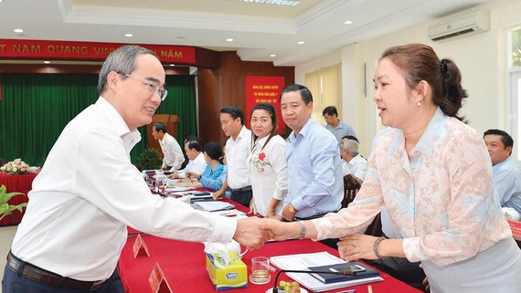 Bí thư Thành uỷ TPHCM Nguyễn Thiện Nhân trao đổi cùng các đồng chí lãnh đạo quận 7. Ảnh: VIỆT DŨNG