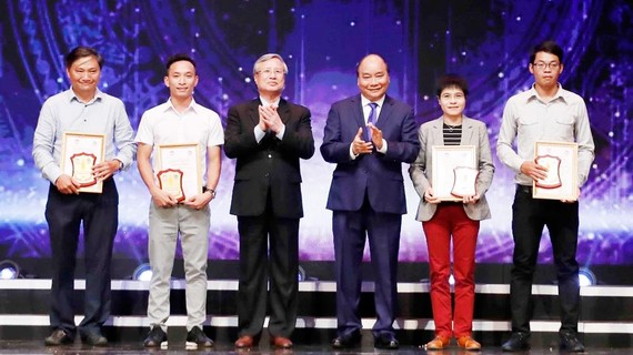 Thủ tướng  Nguyễn Xuân Phúc và Thường trực  Ban Bí thư  Trần Quốc Vượng   trao giải A  cho các tác giả. Ảnh: TTXVN