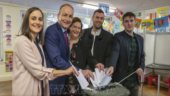 Lãnh đạo đảng đối lập Fianna Fail Michael Martin (thứ hai, bên trái) cùng gia đình bỏ phiếu. Ảnh: AFP/TTXVN