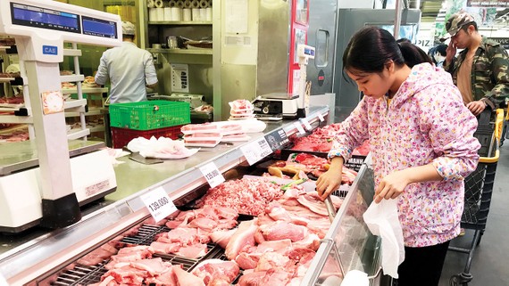 Khách hàng chọn mua thịt heo ở một siêu thị tại TPHCM. Ảnh: THI HỒNG