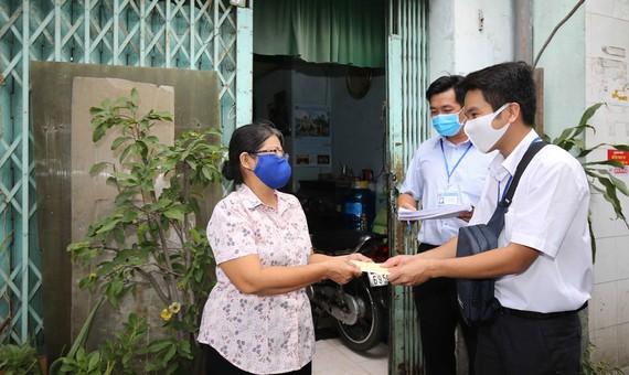 Trao tiền trợ cấp xã hội tận nhà cho người dân phường 9,  quận Phú Nhuận, TPHCM. Ảnh: DŨNG PHƯƠNG