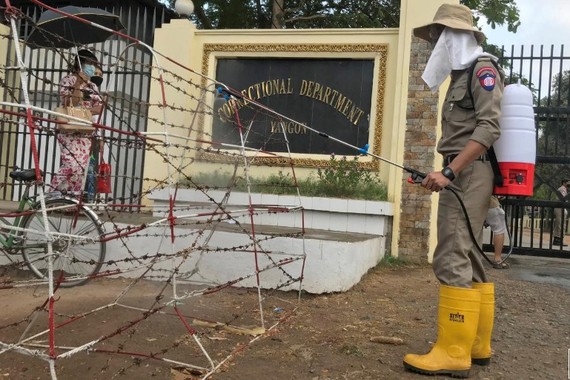 Nhân viên y tế phun khử khuẩn bên ngoài một nhà tù ở Myanmar. Ảnh: Reuters.