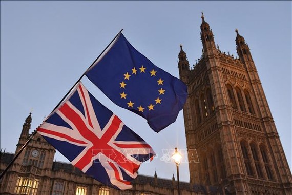 Quốc kỳ Anh và cờ Liên minh châu Âu bên ngoài tòa nhà Quốc hội Anh ở London. Ảnh: AFP/TTXVN
