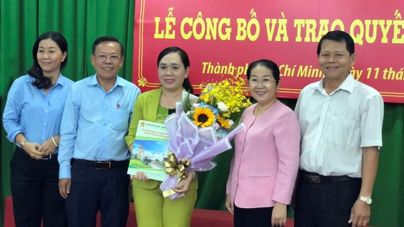 Đồng chí Võ Thị Dung trao quyết định và tặng hoa chúc mừng  đồng chí Nguyễn Thanh Xuân. Ảnh: THÁI PHƯƠNG