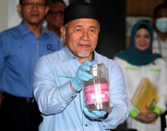 Bộ trưởng Nước và Môi trường Malaysia Tuan Ibrahim Tuan Man cầm trên tay mẫu bụi lò thép độc hại trong các container tại Cảng Tanjung Pelepas ngày 19-7. Nguồn: thestar.com.my