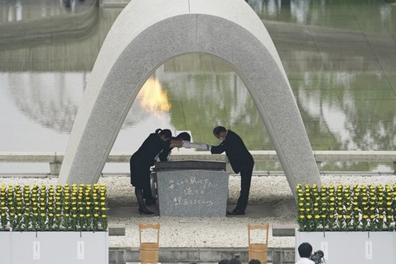 Thị trưởng Matsui Kazumi (phải) nhận và đặt danh sách nạn nhân của vụ ném bom vào bên trong bia tưởng niệm. Ảnh: AP