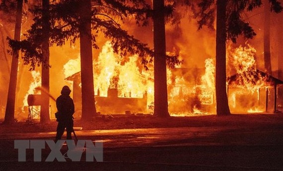 Nhân viên cứu hỏa nỗ lực khống chế các đám cháy rừng Dixie tại California, Mỹ. Ảnh: AFP/TTXVN