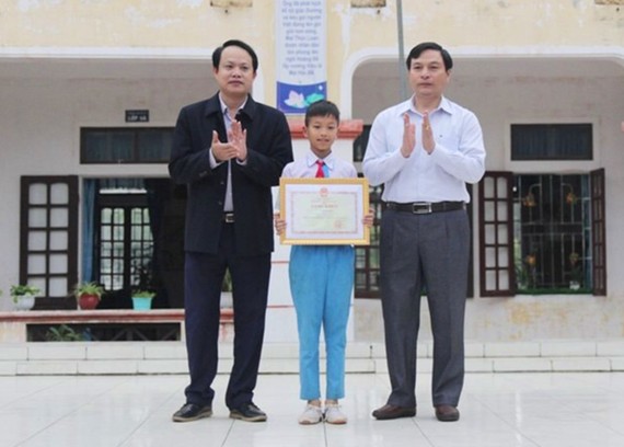 Trao bằng khen của Bộ trưởng Bộ GD-ĐT cho em Võ Hồng Hiếu. Nguồn ảnh: Phòng GD -ĐT huyện Lộc Hà
