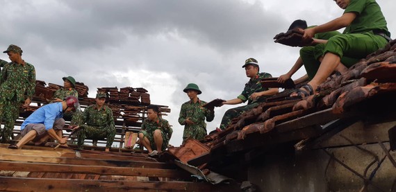 Lực lượng chức năng giúp người dân lợp lại mái nhà sau lốc xoáy