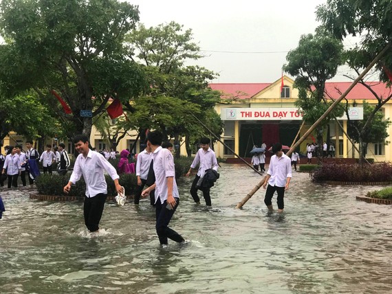 Nhiều em học sinh lội nước đến trường dự lễ khai giảng