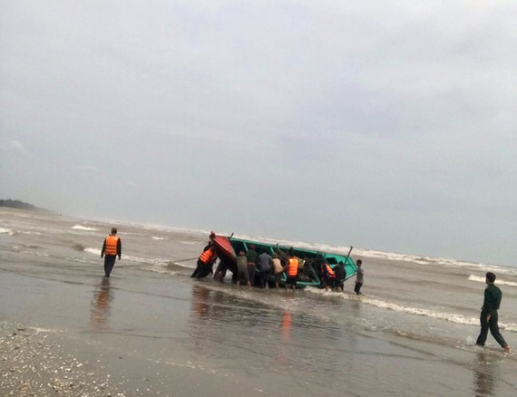 Lực lượng chức năng và người dân tham gia trục vớt thuyền bị nạn đưa vào bờ