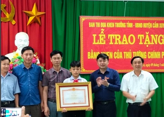 Lãnh đạo Ban Thi đua - Khen thưởng tỉnh Hà Tĩnh và UBND huyện Cẩm Xuyên trao bằng khen của Thủ tướng Chính phủ cho em Nguyễn Văn Dương
