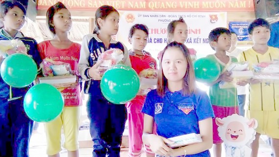 Chị Nguyễn Thị Như Ngọc (hàng đầu) trao quà cho trẻ có hoàn cảnh khó khăn