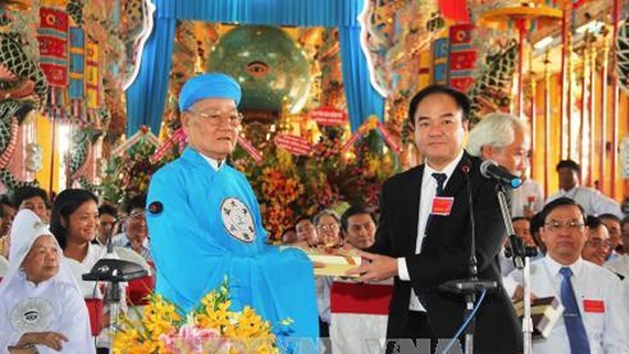 Đầu sư Thượng tám Thanh, Chưởng quản Hội thánh cao Đài Tây Ninh nhận quà chúc mừng của Ban Tôn giáo Chính phủ. Ảnh: TTXVN