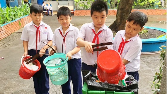Học sinh Trường Tiểu học Lý Nhân Tông, quận 8 (TPHCM) thu gom rác  ở trường, thực hiện phân loại rác tại nguồn       Ảnh: THÀNH TRÍ