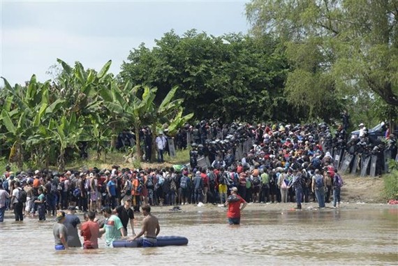 Người di cư băng qua sông Suchiate từ Ciudad Tecun Uman (Guatemala) để tới Ciudad Hidalgo (Mexico) trong hành trình đến Mỹ. Nguồn: TTXVN