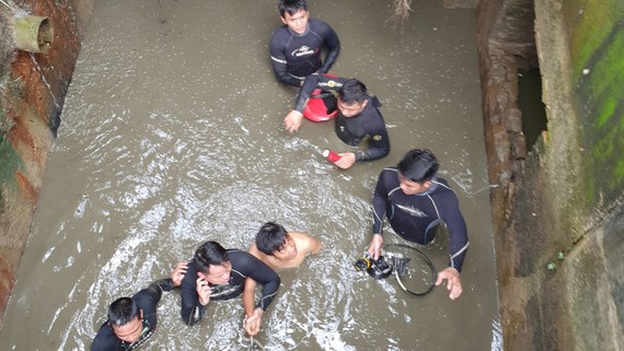 Thượng úy Trần Thành Phát cùng đồng đội đưa nạn nhân mắc kẹt  trong cống thoát nước ra ngoài 