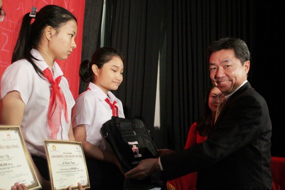 Ông Tatsuya Nakayama, Giám đốc Khối Sản xuất, Công ty Ajinomoto Việt Nam trao học bổng cho các em học sinh