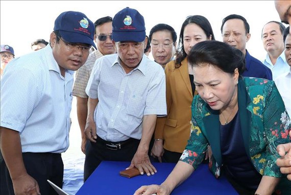 Chủ tịch Quốc hội Nguyễn Thị Kim Ngân xem công nghệ cho cá ăn ứng dụng qua hệ thống vi tính tại vùng nuôi cá tra ứng dụng công nghệ cao. Ảnh: TTXVN
