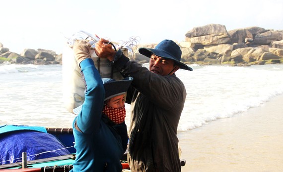 Người thân của ngư dân làng lưới thúng Trung Lương mang cá đi bán tại các phiên chợ gần làng